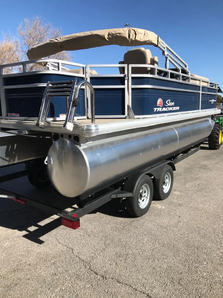 Slide: The Image of 2025 Sun Tracker Fishin' Barge 20 DLX pontoon boat on trailer, rear view. - 5