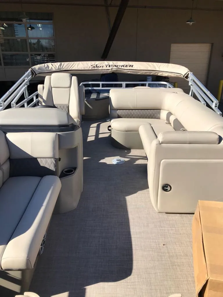 Slide: The Image of 2025 Sun Tracker Fishin' Barge 20 DLX interior with beige seating and spacious layout. - 9