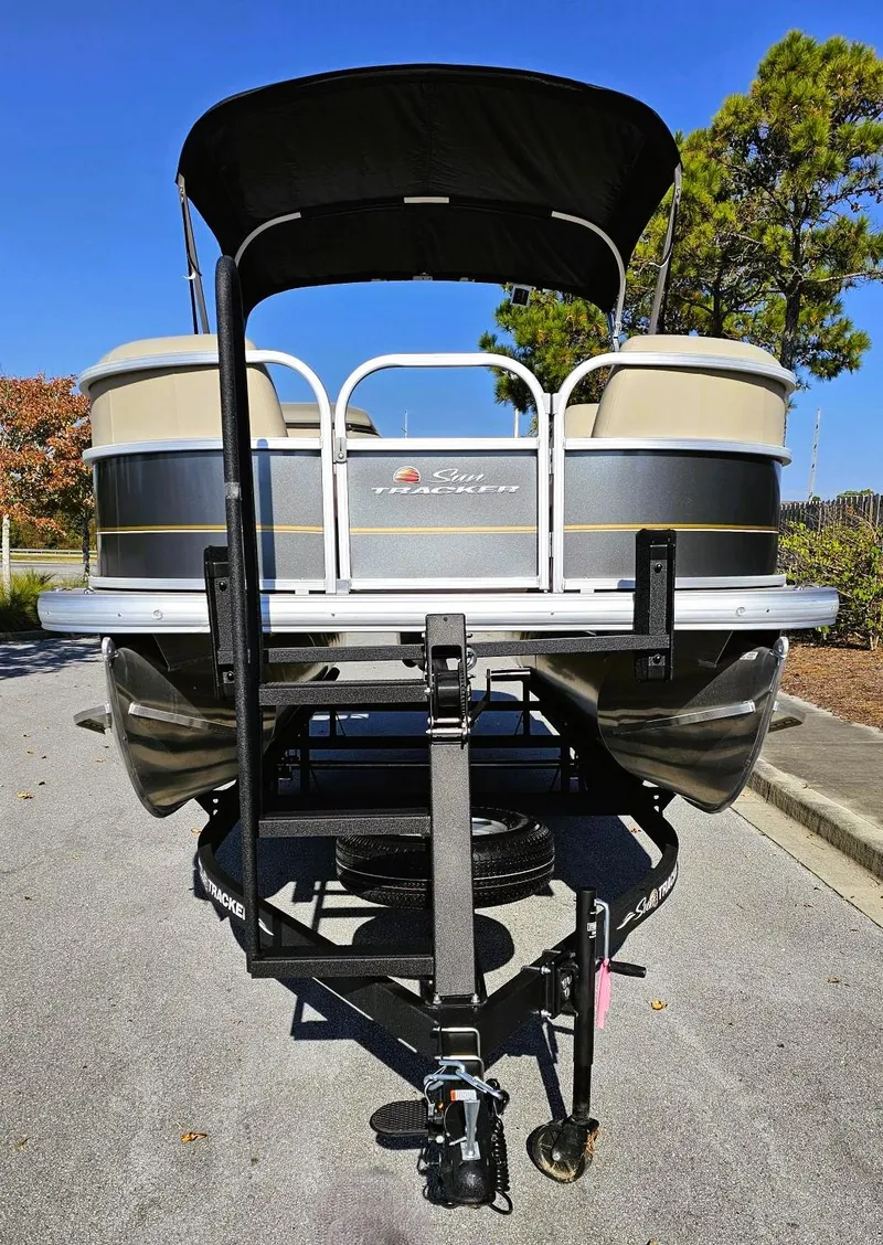Slide: The Image of 2025 Sun Tracker Party Barge 18 DLX pontoon boat on trailer, sunny day. - 5