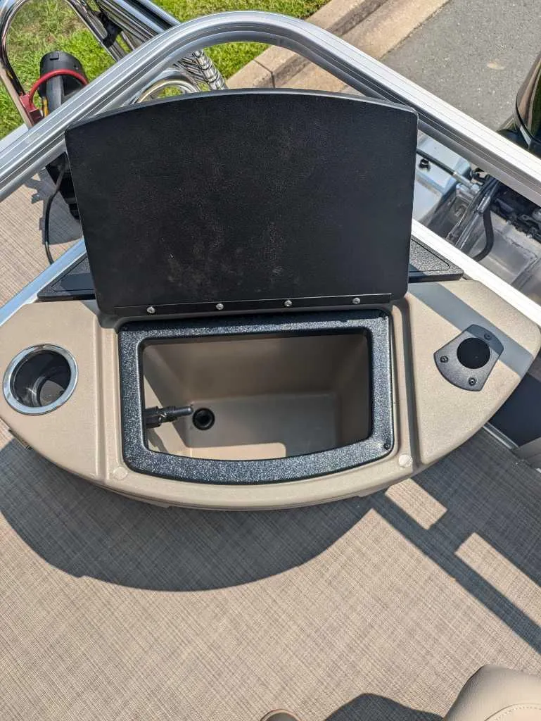 Slide: The Image of 2025 Sun Tracker Bass Buggy 18 DLX boat storage compartment with cup holders. - 12