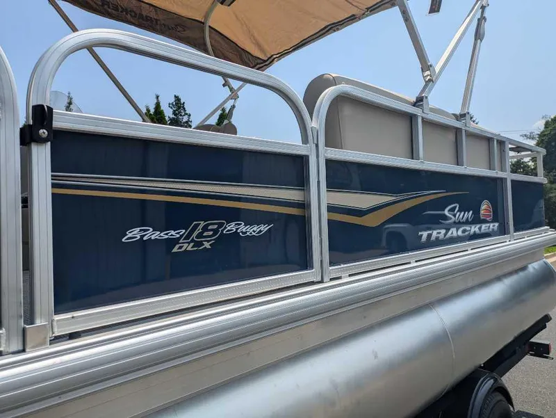 Slide: The Image of 2025 Sun Tracker Bass Buggy 18 DLX pontoon boat with blue and silver detailing. - 13