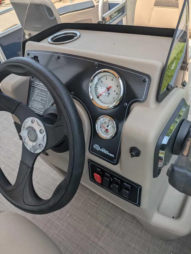 Slide: The Image of 2025 Sun Tracker Bass Buggy 18 DLX dashboard with steering wheel and gauges. - 6