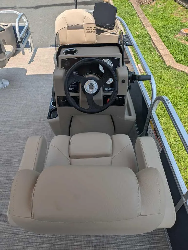 Slide: The Image of 2025 Sun Tracker Bass Buggy 18 DLX boat interior with steering wheel and seating. - 7