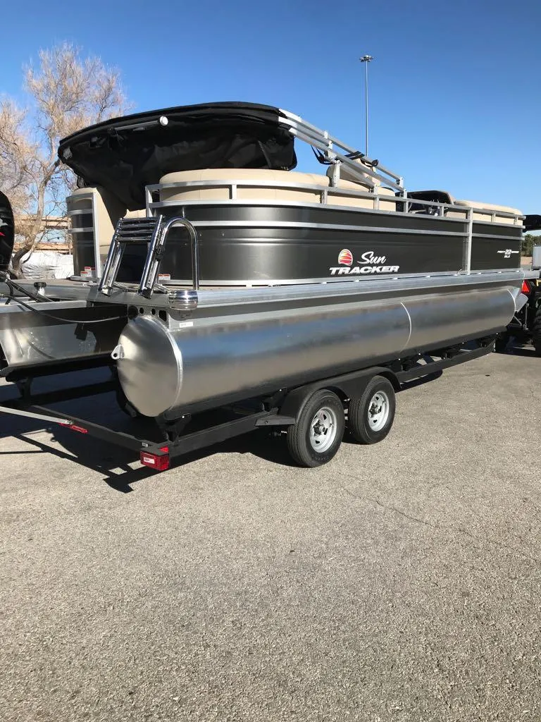 Slide: The Image of 2025 Sun Tracker Party Barge 22 DLX pontoon boat on trailer. - 2