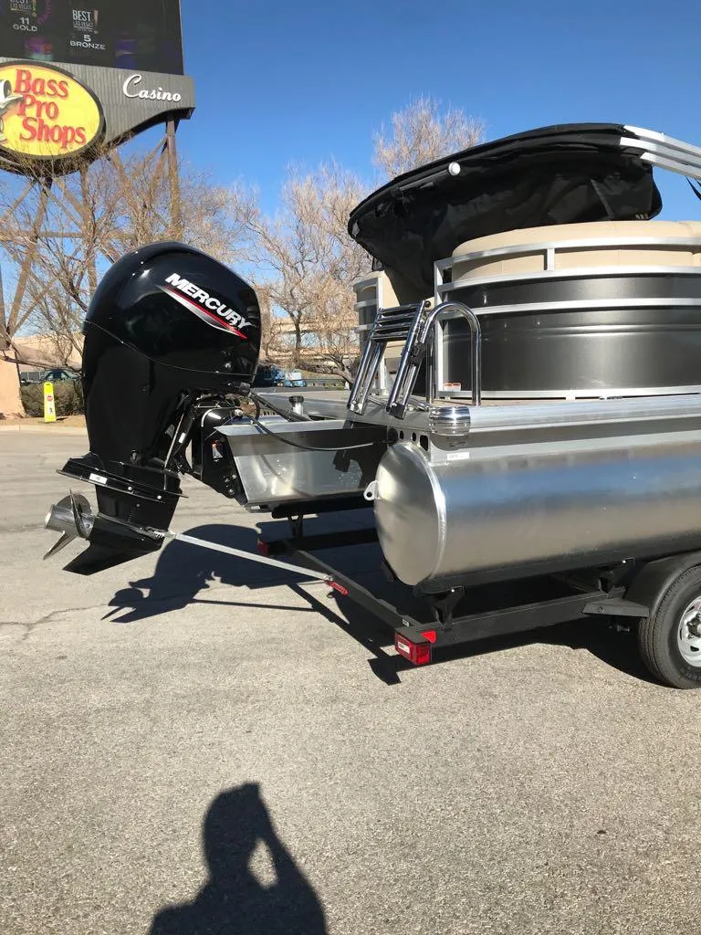 Slide: The Image of 2025 Sun Tracker Party Barge 22 DLX with Mercury engine in parking lot. - 3