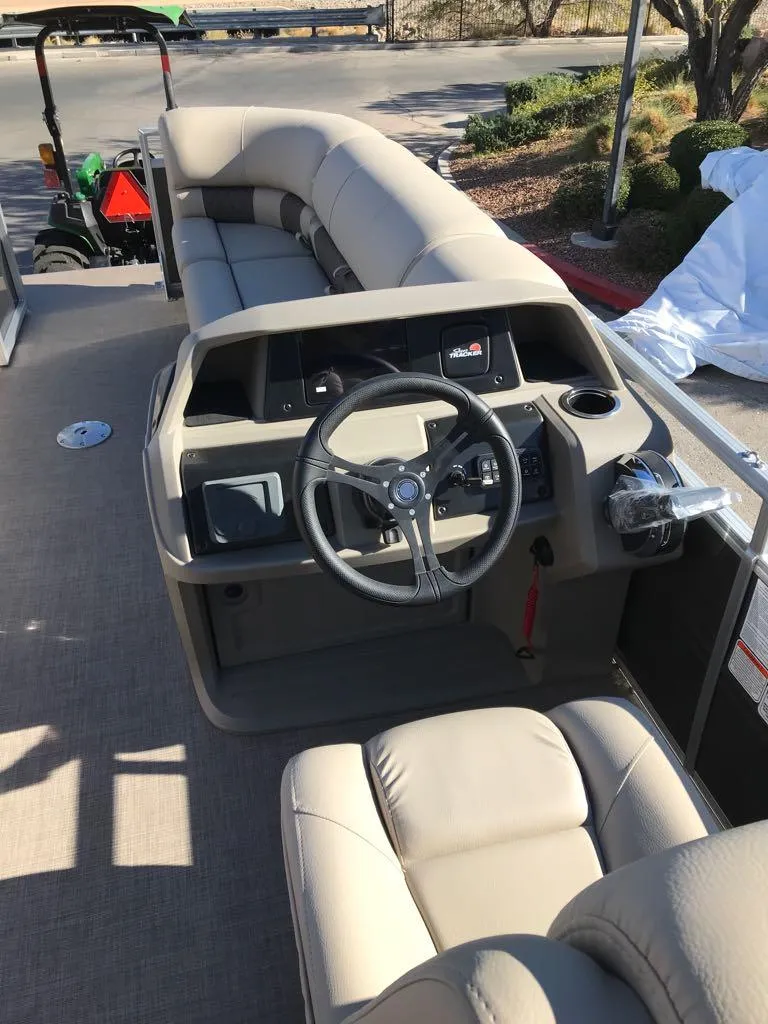 Slide: The Image of 2025 Sun Tracker Party Barge 22 DLX interior with steering wheel and seating. - 7