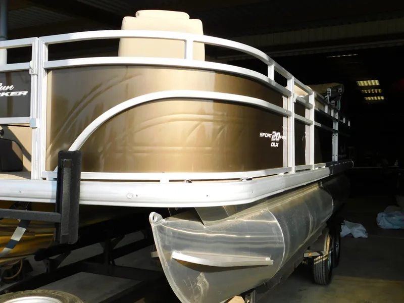 Slide: The Image of 2025 Sun Tracker SportFish 20 DLX pontoon boat in a garage setting. - 5