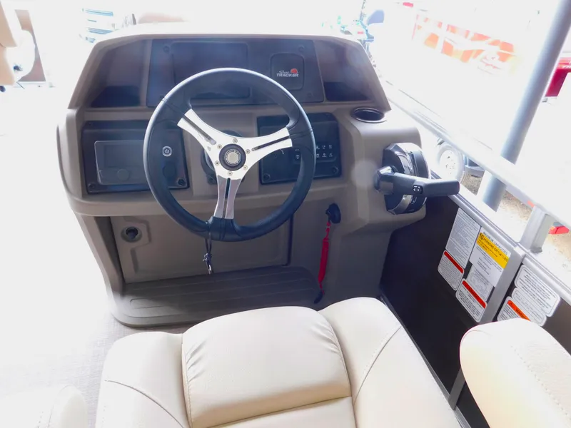 Slide: The Image of 2025 Sun Tracker SportFish 20 DLX boat dashboard with steering wheel and controls. - 7