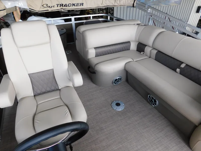 Slide: The Image of 2025 Sun Tracker SportFish 20 DLX pontoon boat interior with beige seating and steering wheel. - 9