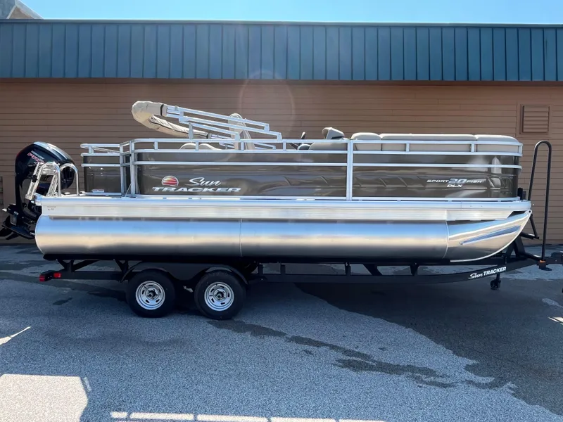 The Image of 2025 Sun Tracker SportFish 20 DLX pontoon boat on trailer, parked outdoors. - 0