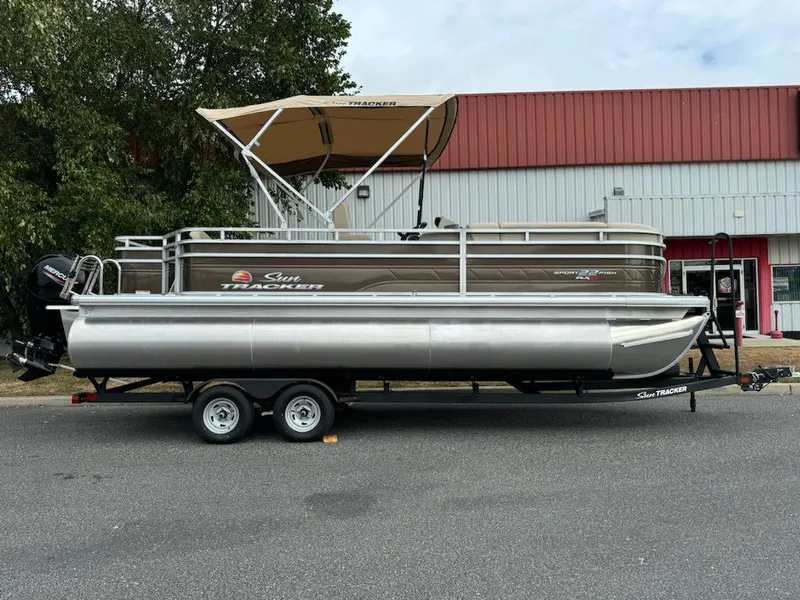 The Image of 2025 Sun Tracker SportFish 22 XP3 pontoon boat on trailer, parked outdoors. - 0