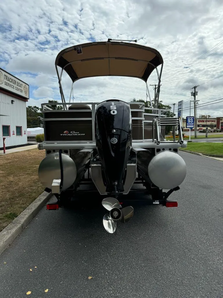 Slide: The Image of 2025 Sun Tracker SportFish 22 XP3 pontoon boat with canopy and outboard motor. - 2