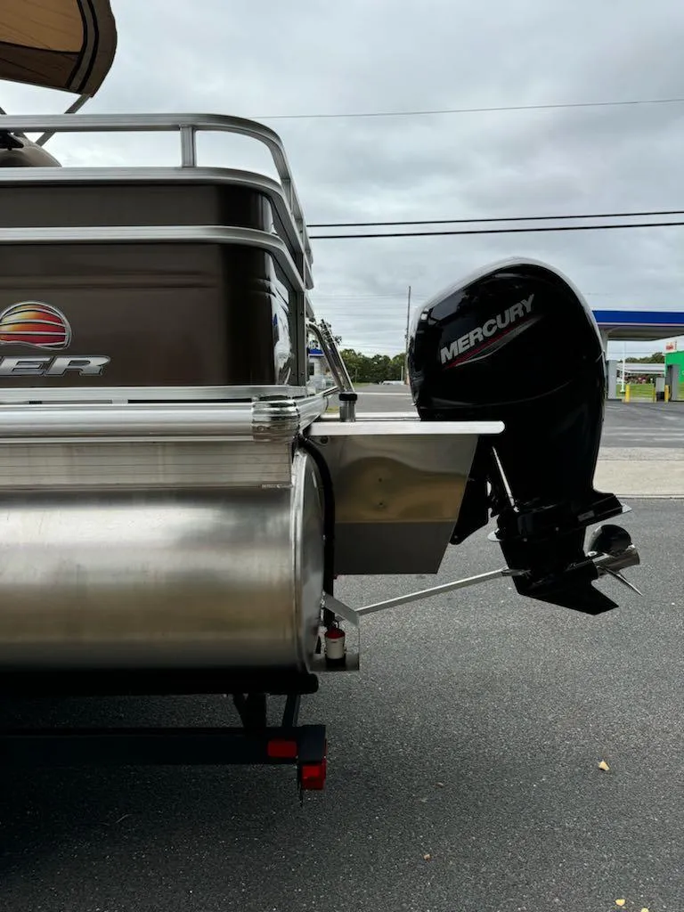 Slide: The Image of 2025 Sun Tracker SportFish 22 XP3 with Mercury outboard motor, parked on asphalt. - 5