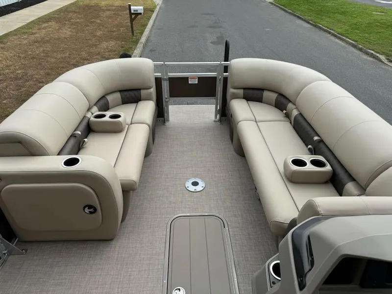 Slide: The Image of 2025 Sun Tracker SportFish 22 XP3 pontoon boat with beige seating and cup holders. - 7