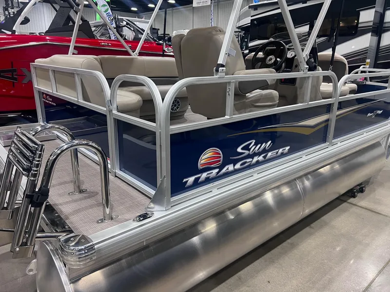 Slide: The Image of 2025 Sun Tracker Bass Buggy 16 XL Select pontoon boat on display indoors. - 2
