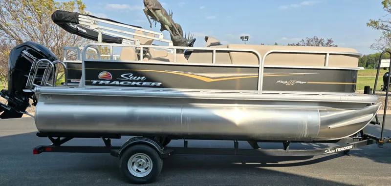 Slide: The Image of 2025 Sun Tracker Party Barge 18 DLX pontoon boat on trailer. - 2