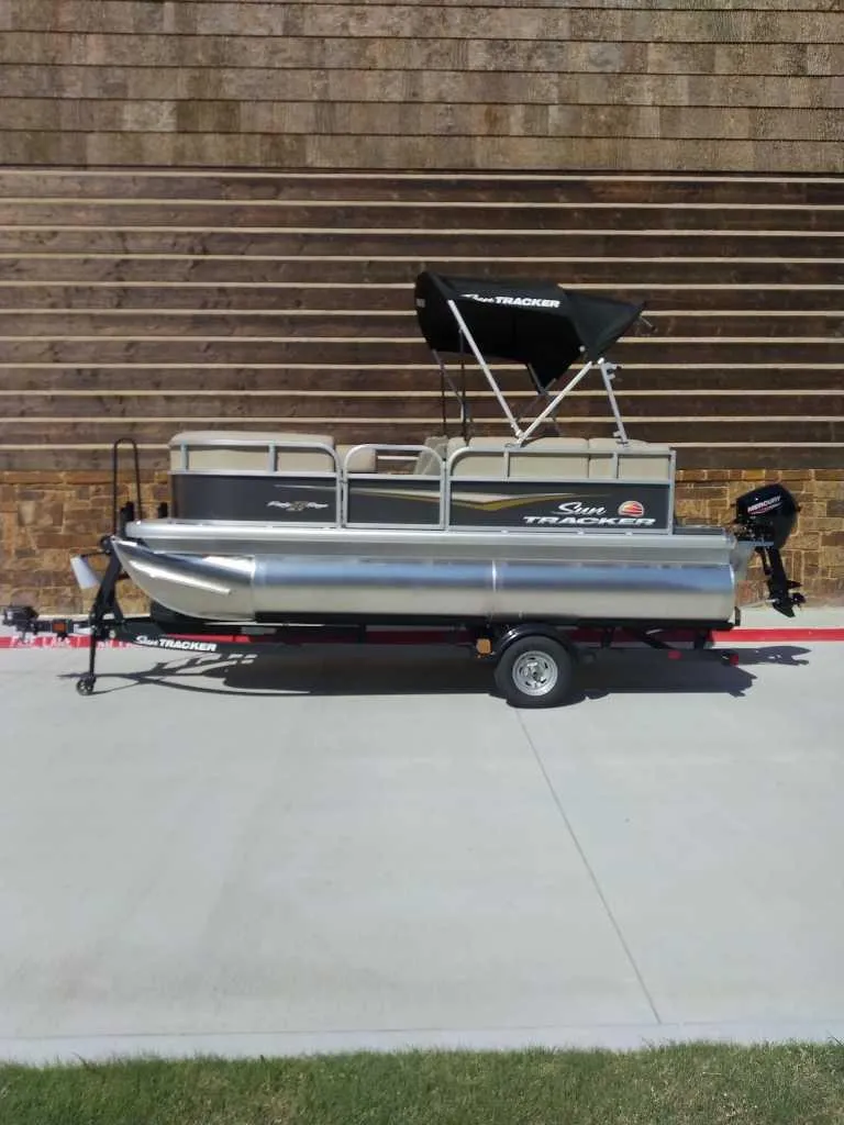 Slide: The Image of 2025 Sun Tracker Party Barge 16 DLX pontoon boat on trailer, side view. - 0