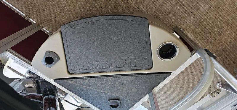 Slide: The Image of 2025 Sun Tracker Bass Buggy 18 DLX boat console with ruler and cup holder. - 16