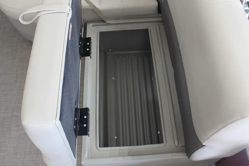 Slide: The Image of 2025 Sun Tracker Party Barge 18 DLX storage compartment with open seat cushion. - 11