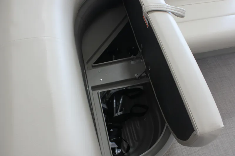 Slide: The Image of 2025 Sun Tracker Party Barge 18 DLX storage compartment with open seat revealing interior space. - 12
