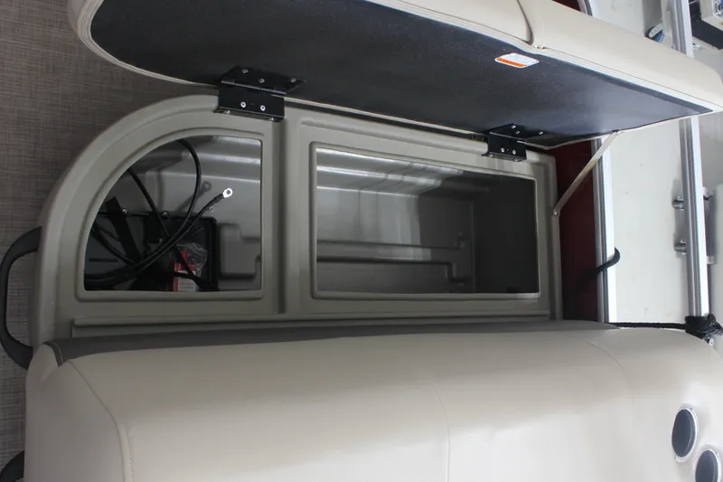 Slide: The Image of 2025 Sun Tracker Party Barge 18 DLX storage compartment with open lid and visible wiring. - 14