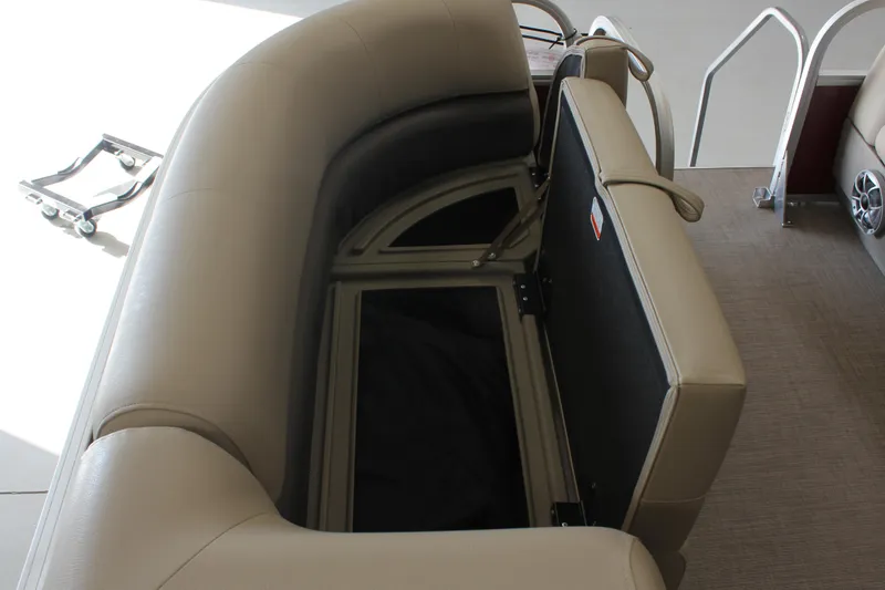 Slide: The Image of 2025 Sun Tracker Party Barge 18 DLX with open storage compartment and beige seating. - 4