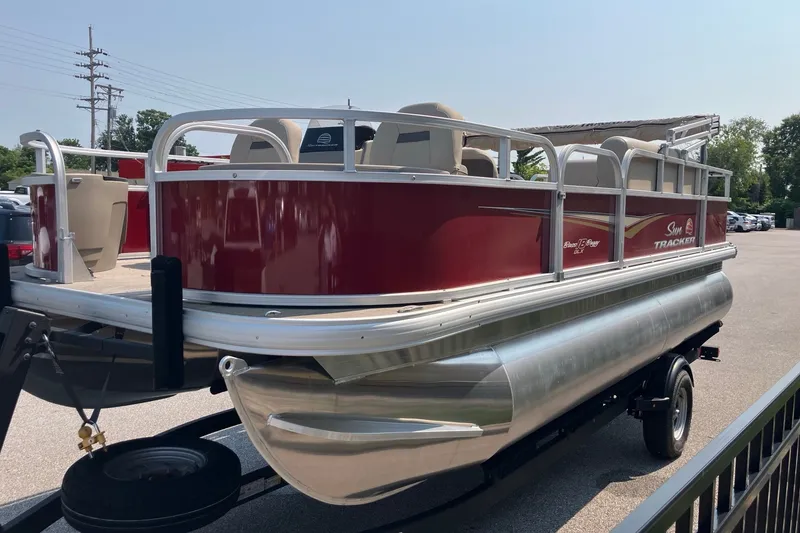 Slide: The Image of 2025 Sun Tracker Bass Buggy 18 DLX pontoon boat on trailer, red and silver design. - 6