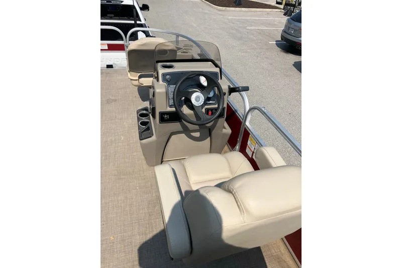Slide: The Image of 2025 Sun Tracker Bass Buggy 18 DLX boat interior with steering console and beige seating. - 9
