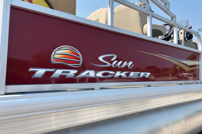 Slide: The Image of 2025 Sun Tracker Bass Buggy 18 DLX pontoon boat with logo detail. - 2
