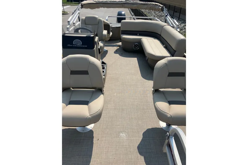 Slide: The Image of 2025 Sun Tracker Bass Buggy 18 DLX pontoon boat interior with beige seating and spacious layout. - 8