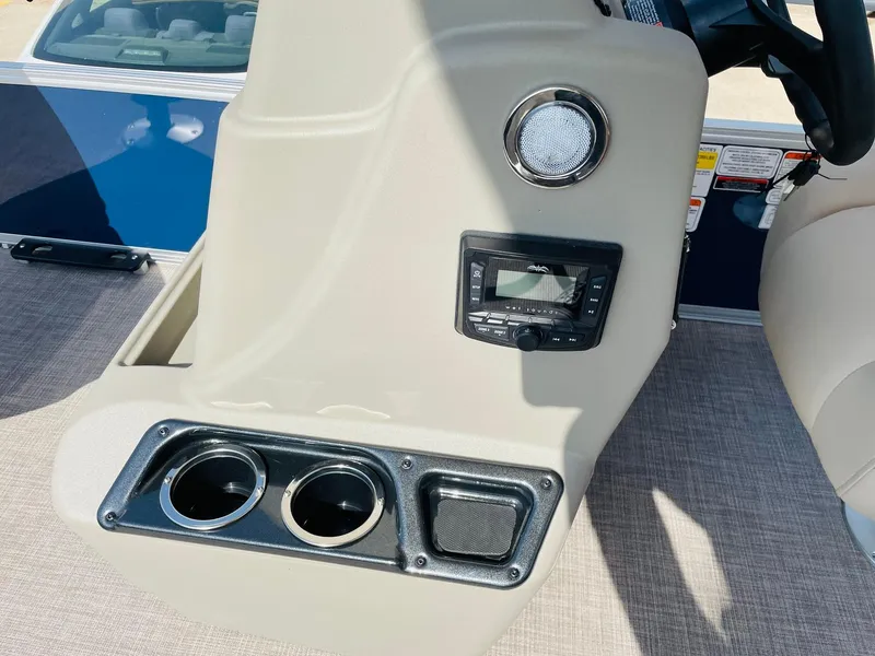 Slide: The Image of 2025 Sun Tracker Bass Buggy 18 DLX console with cup holders and audio controls. - 18