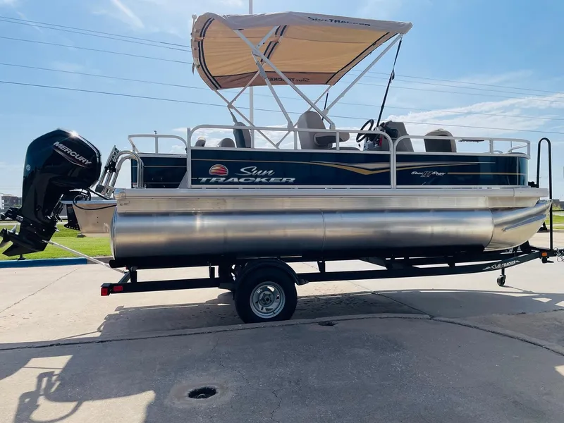 Slide: The Image of 2025 Sun Tracker Bass Buggy 18 DLX pontoon boat with canopy on trailer. - 4