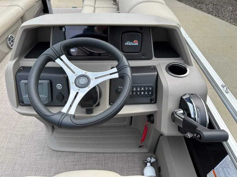 Slide: The Image of 2025 Sun Tracker SportFish 22 DLX boat dashboard with steering wheel and controls. - 5