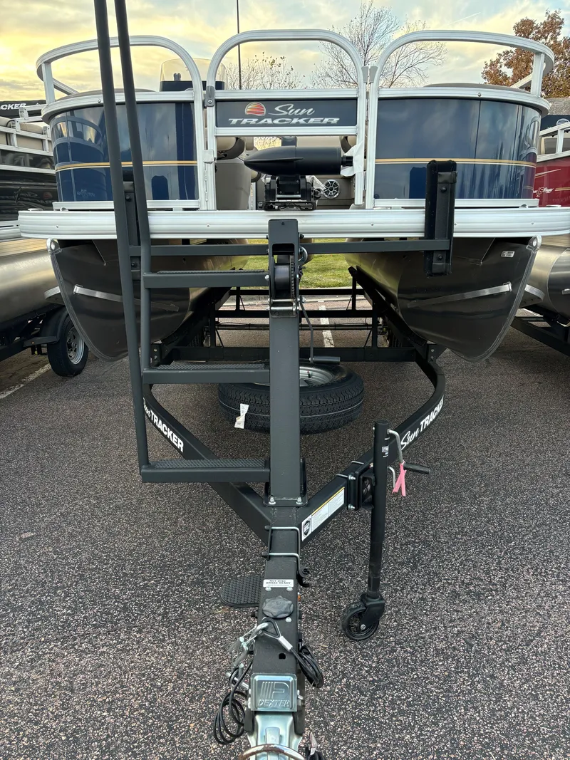Slide: The Image of 2025 Sun Tracker Bass Buggy 18 DLX pontoon boat on trailer, front view. - 2
