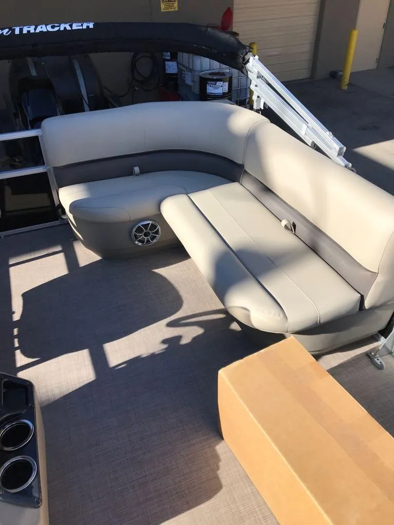 Slide: The Image of 2025 Sun Tracker Party Barge 16 DLX interior with beige seating and cup holders. - 12