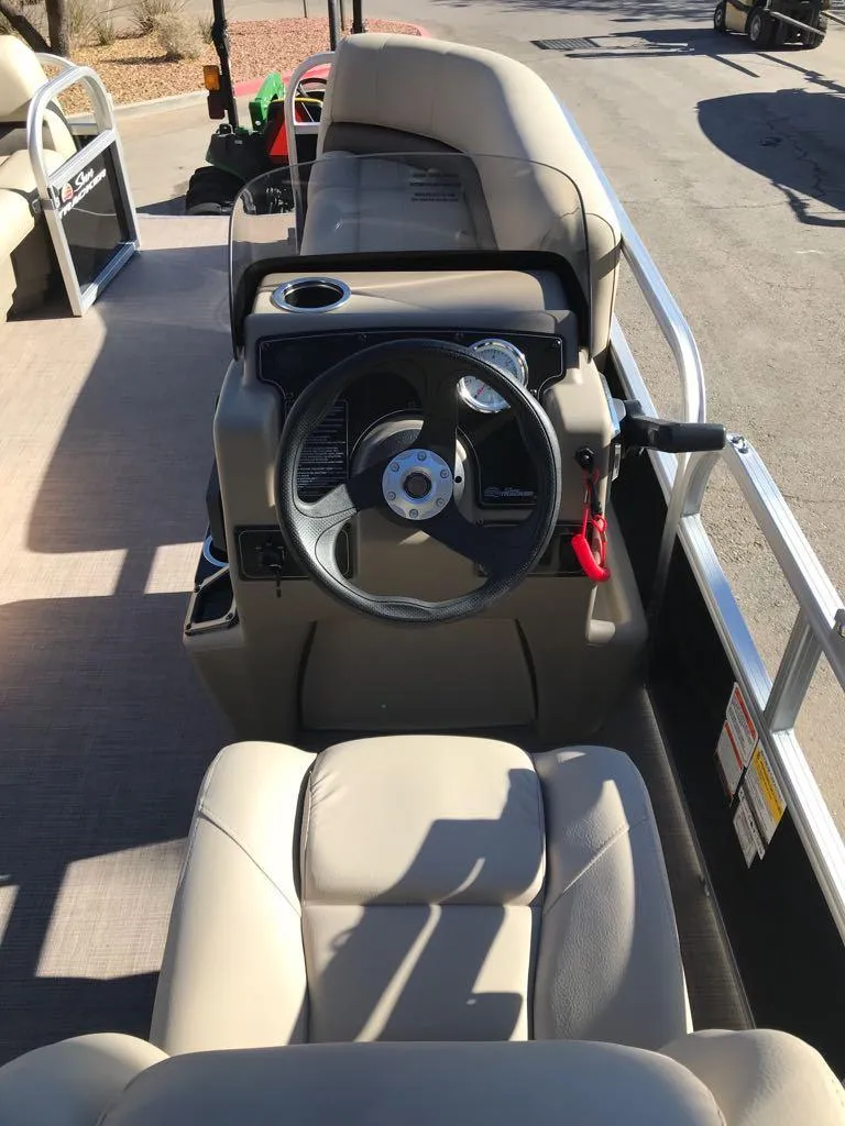 Slide: The Image of 2025 Sun Tracker Party Barge 16 DLX interior with steering wheel and seating. - 7