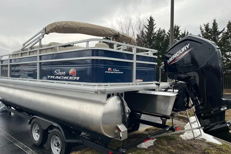 Slide: The Image of 2025 Sun Tracker Fishin' Barge 20 DLX pontoon boat with Mercury outboard motor on trailer. - 3