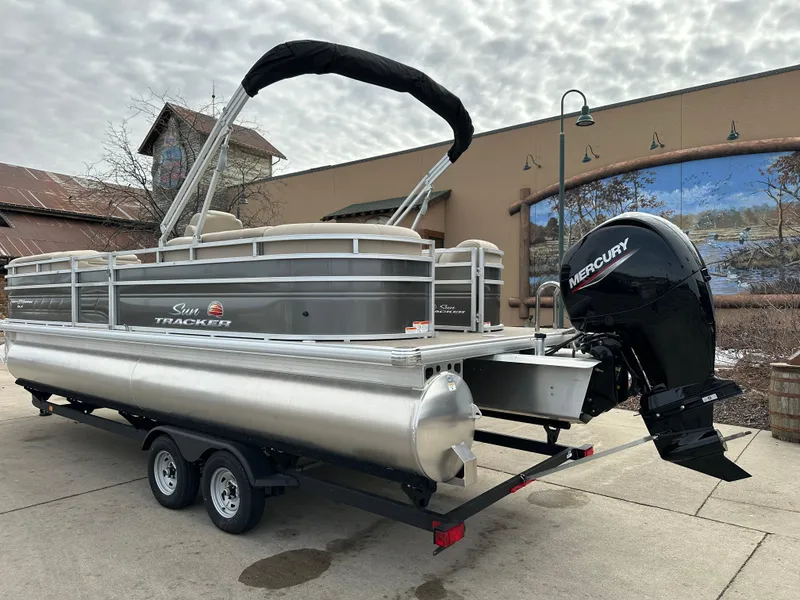Slide: The Image of 2025 Sun Tracker Party Barge 24 DLX pontoon boat with Mercury engine on trailer. - 2