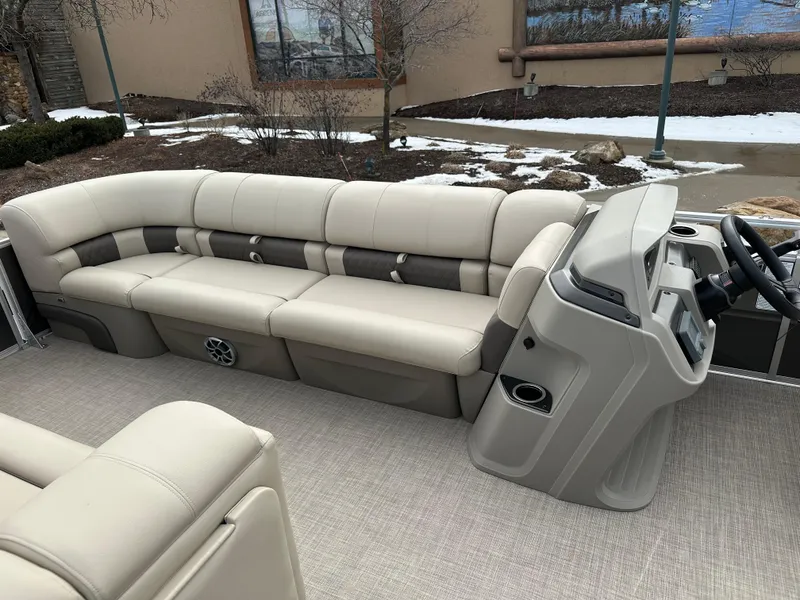 Slide: The Image of 2025 Sun Tracker Party Barge 24 DLX interior with beige seating and helm. - 5