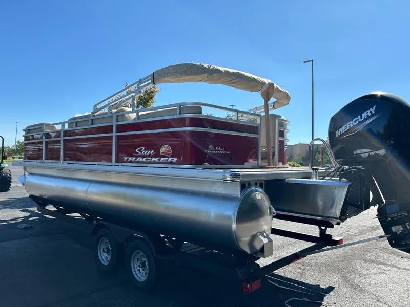 Slide: The Image of 2025 Sun Tracker Party Barge 22 RF DLX pontoon boat on trailer, with Mercury outboard motor. - 2