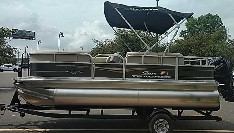 Slide: The Image of 2025 Sun Tracker Party Barge 18 DLX pontoon boat with canopy on trailer. - 2