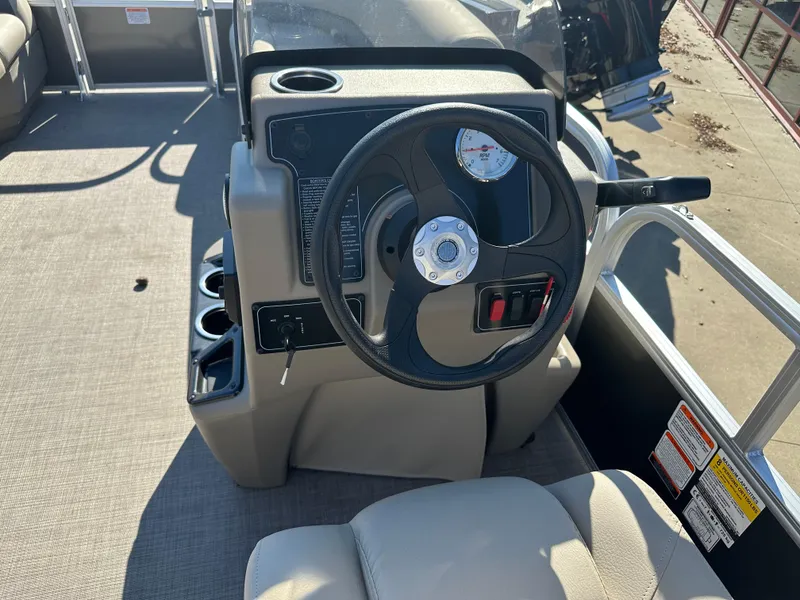 Slide: The Image of 2025 Sun Tracker Party Barge 16 DLX steering console with cup holders and gauges. - 6