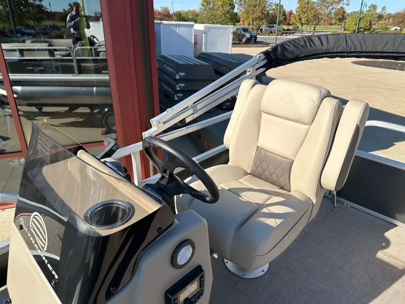 Slide: The Image of 2025 Sun Tracker Party Barge 16 DLX helm with beige captain's chair and steering wheel. - 7
