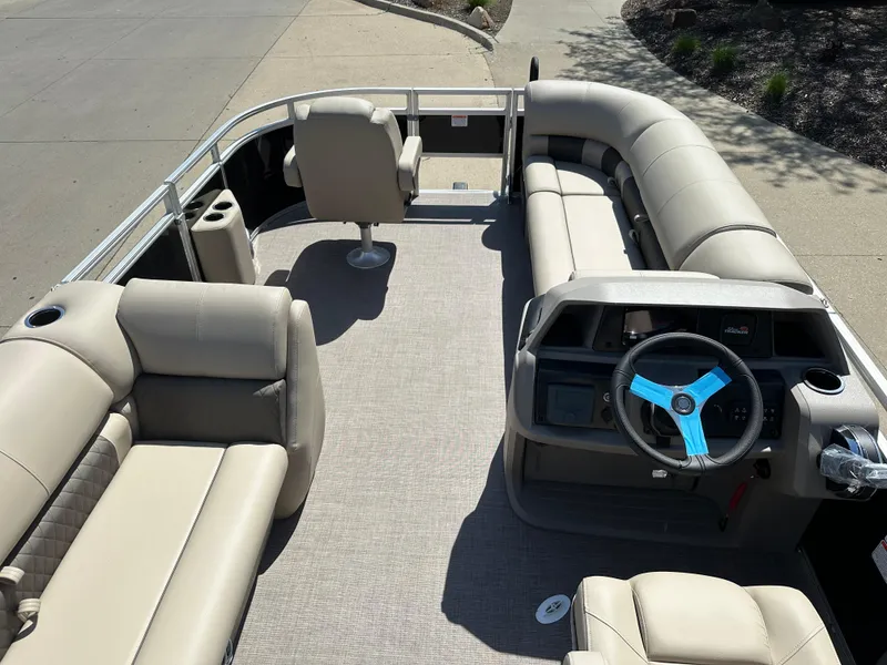 Slide: The Image of 2025 Sun Tracker SportFish 20 DLX pontoon boat interior with beige seating and steering wheel. - 3