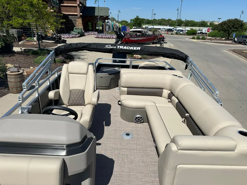 Slide: The Image of 2025 Sun Tracker SportFish 20 DLX pontoon boat with beige seating and spacious deck. - 5