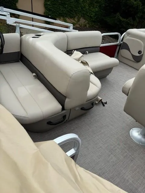 Slide: The Image of 2025 Sun Tracker Party Barge 18 DLX interior with beige seating and carpeted floor. - 4