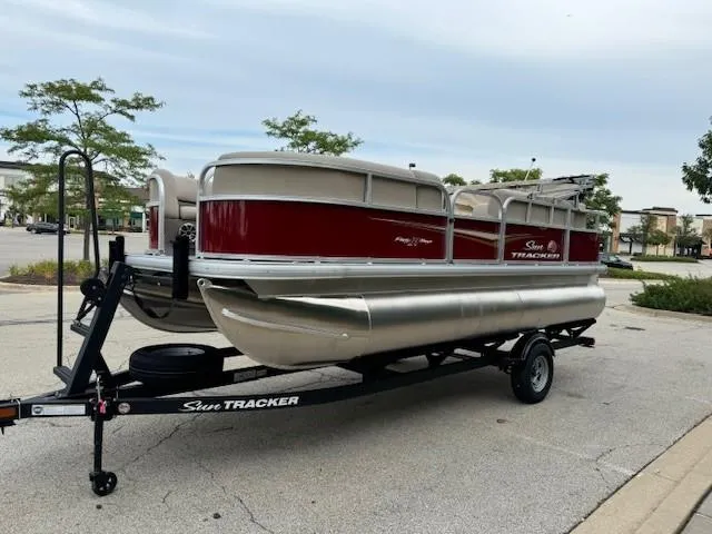 Slide: The Image of 2025 Sun Tracker Party Barge 18 DLX pontoon boat on trailer in parking lot. - 6