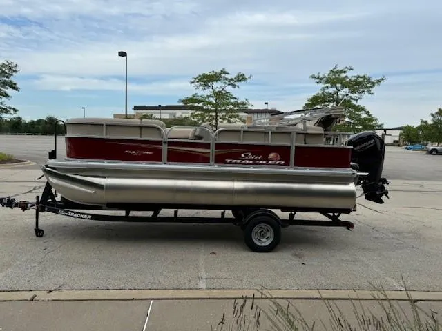 Slide: The Image of 2025 Sun Tracker Party Barge 18 DLX pontoon boat on trailer in parking lot. - 7