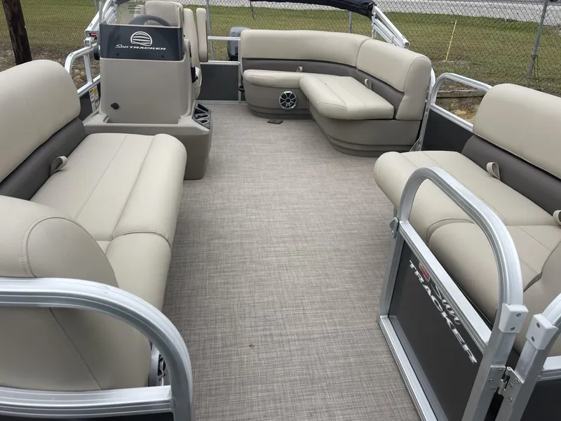 Slide: The Image of 2025 Sun Tracker Party Barge 16 DLX interior with beige seating and spacious layout. - 7