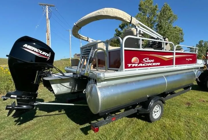 Slide: The Image of 2025 Sun Tracker Bass Buggy 16 XL Select pontoon boat with Mercury engine on trailer. - 5